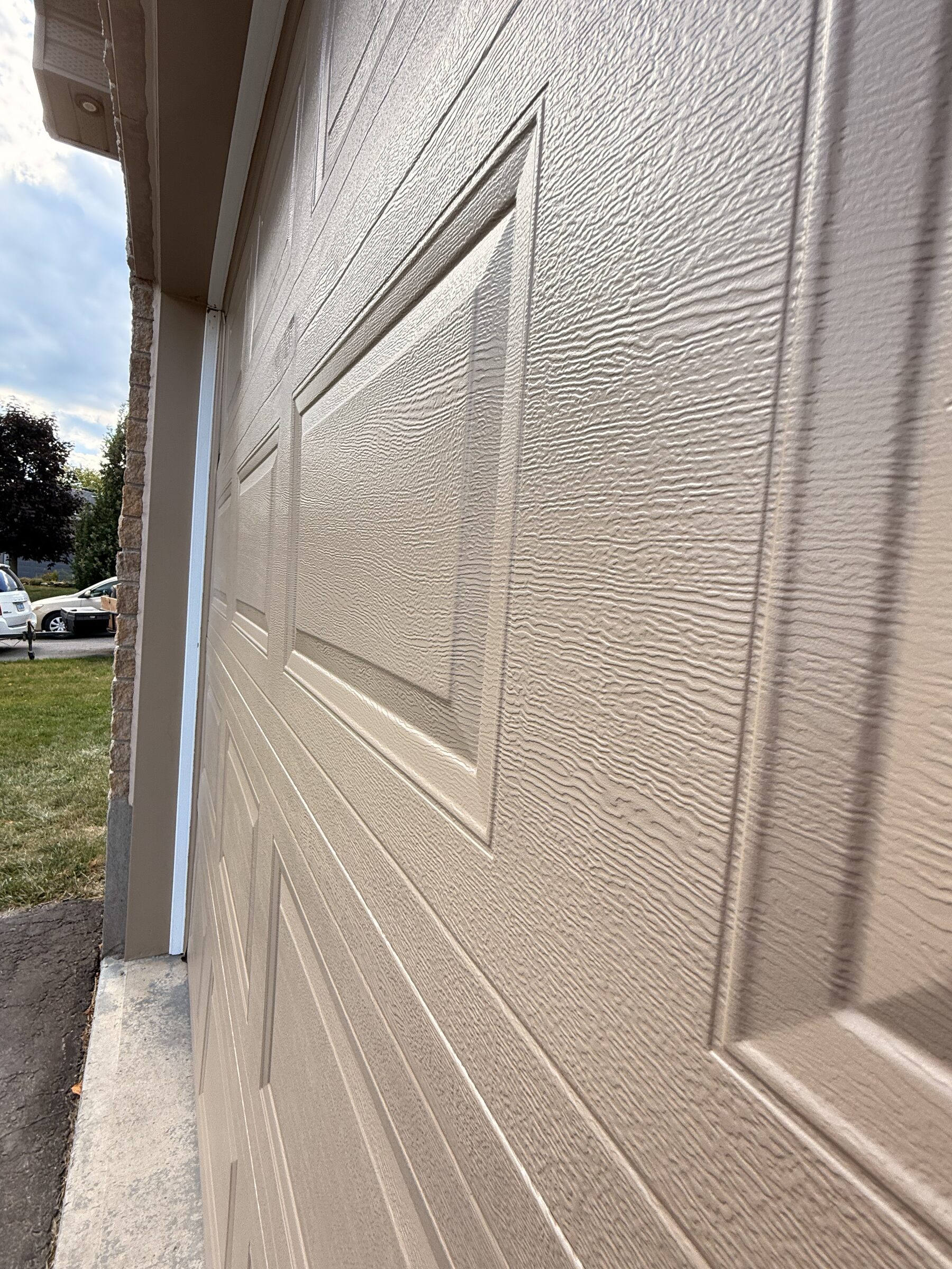 After: Finished garage door in textured beige with the raised panel detail picked out