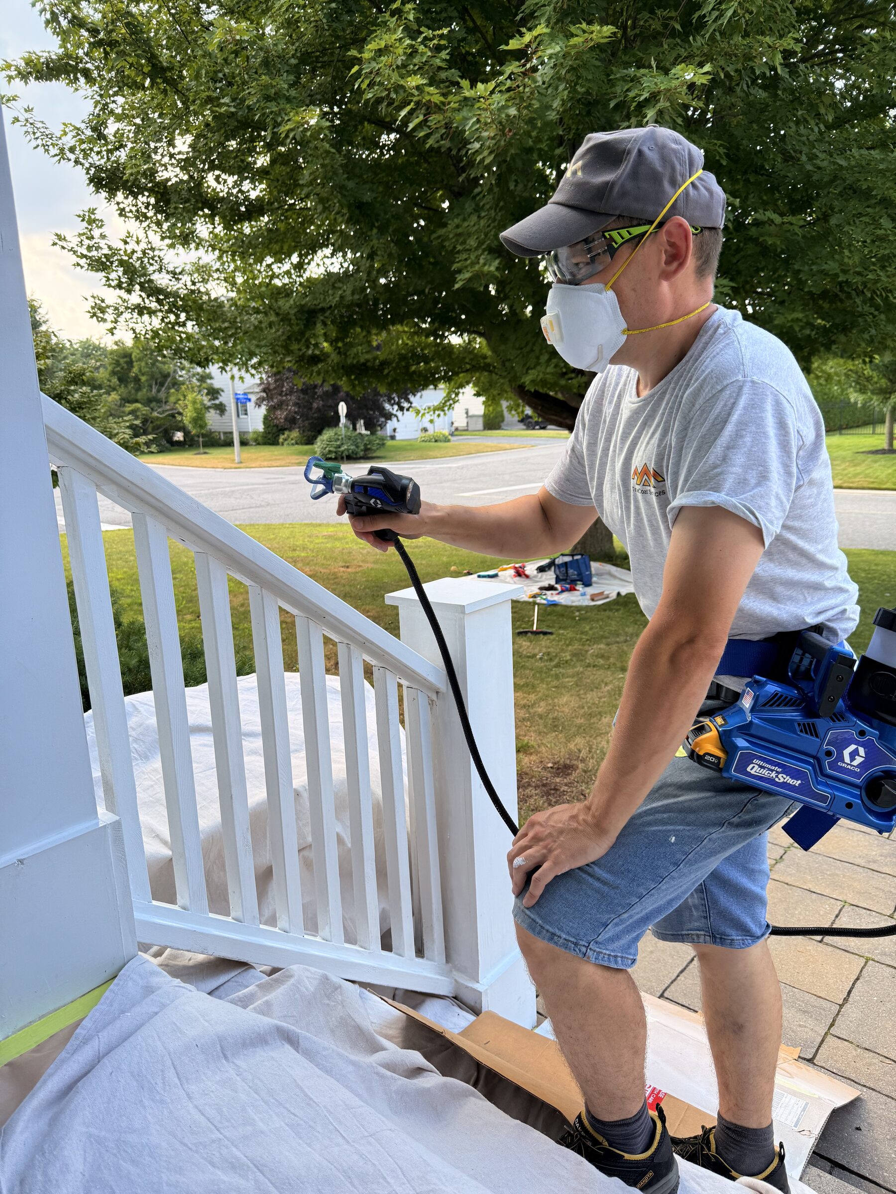 Porch railing being sprayed white in Stittsville