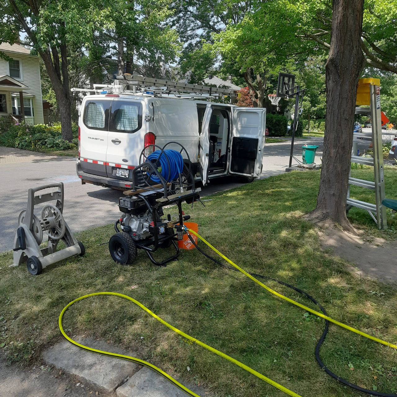 TrueCoat service van and professional pressure-washing equipment set up on a residential street